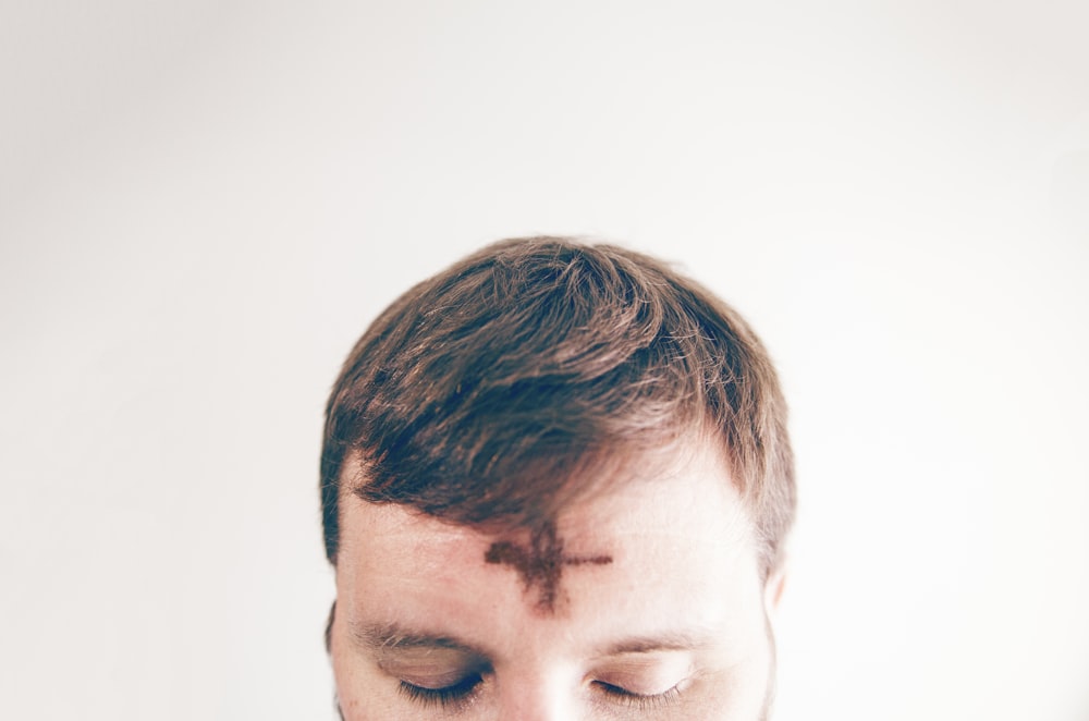 man with brown hair looking down