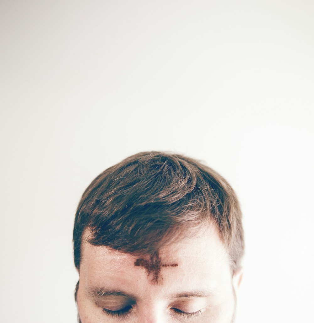 man with brown hair looking down