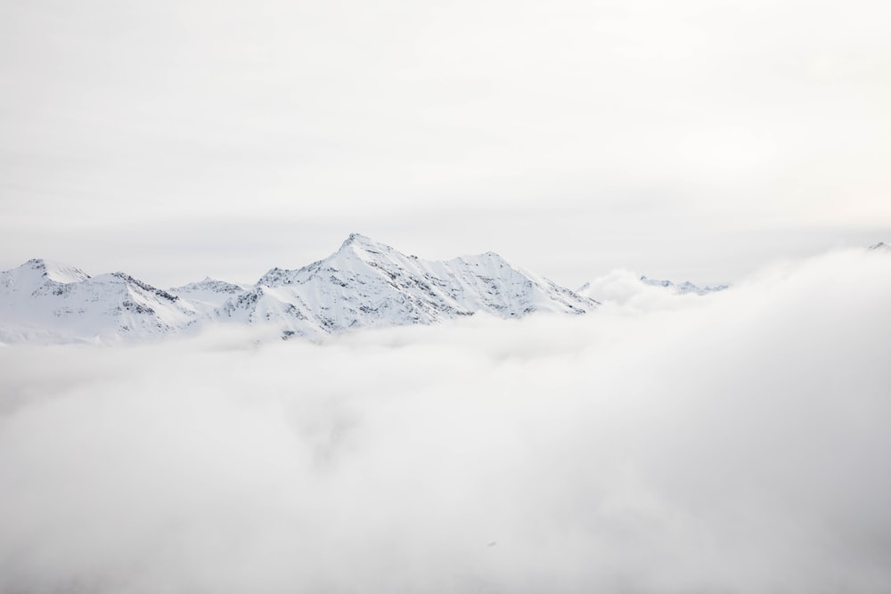 Chaîne de montagnes couverte de neige et de nuages pendant la journée