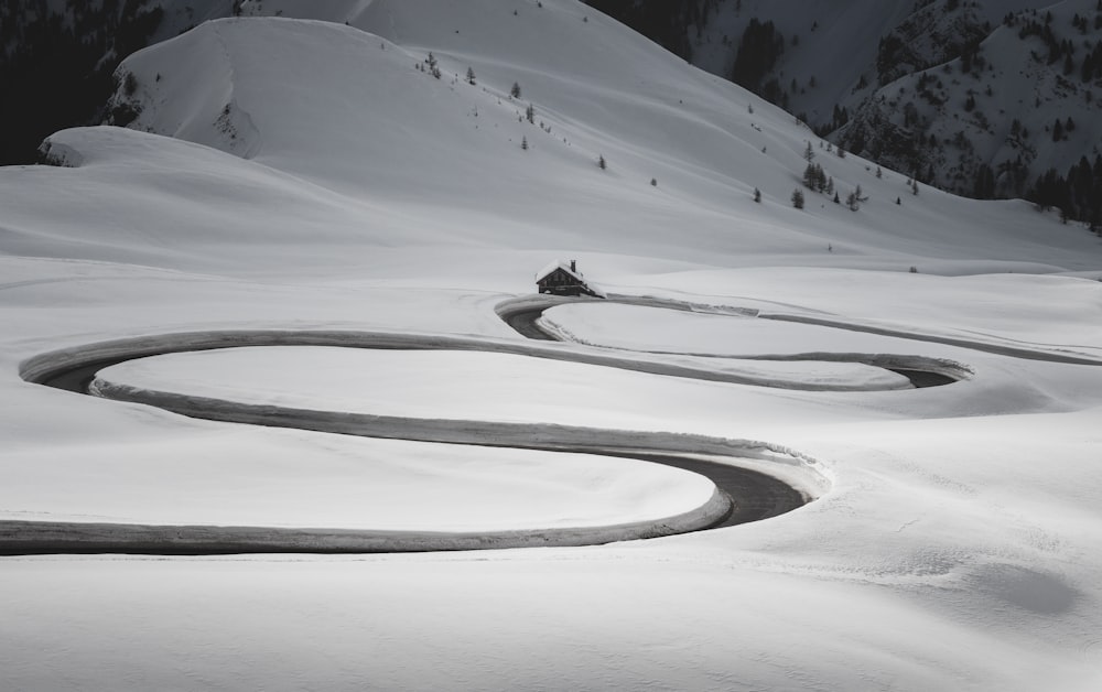 uma estrada sinuosa no meio de uma montanha coberta de neve