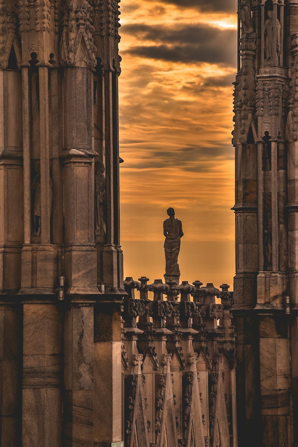 low-light photo of woman statue in the middle of high-rise building