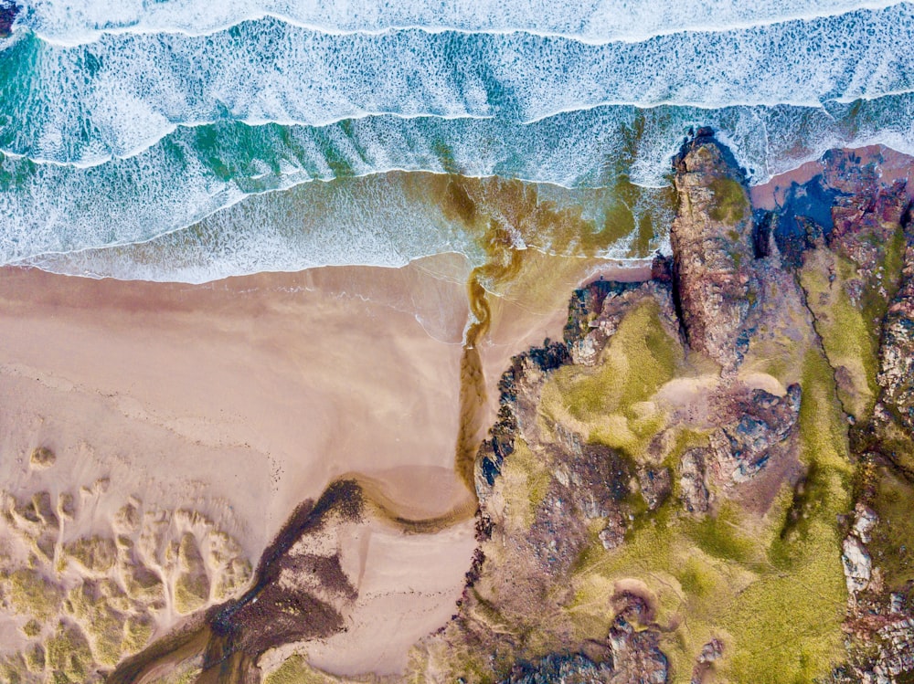 Fotografía aérea de la montaña verde y la orilla del mar durante el día