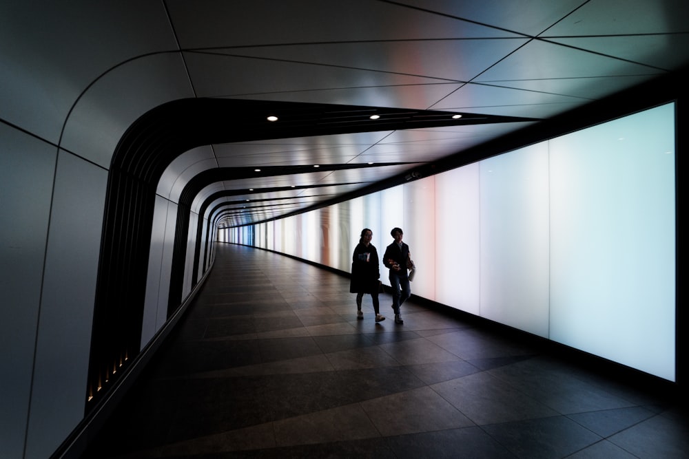 two people walking on hallway