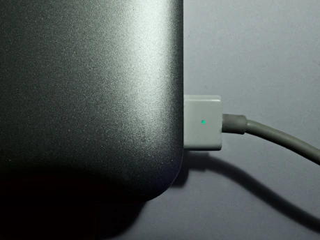 A close-up of a hand unplugging a network cable from a laptop, symbolizing disconnecting from big tech.