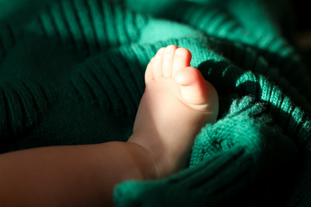 a close up of a baby's foot on a blanket