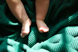 A soft morning light casting gentle shadows over a tiny pair of baby shoes on a wooden floor.
