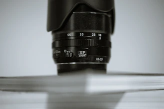 Close-up of a professional camera lens focusing on a speaker at a corporate seminar.