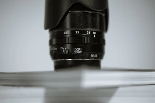 Close-up of a professional camera lens focusing on a speaker at a corporate seminar.