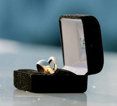 silver-colored bridal ring set on box on top of white surface