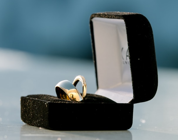 silver-colored bridal ring set on box on top of white surface