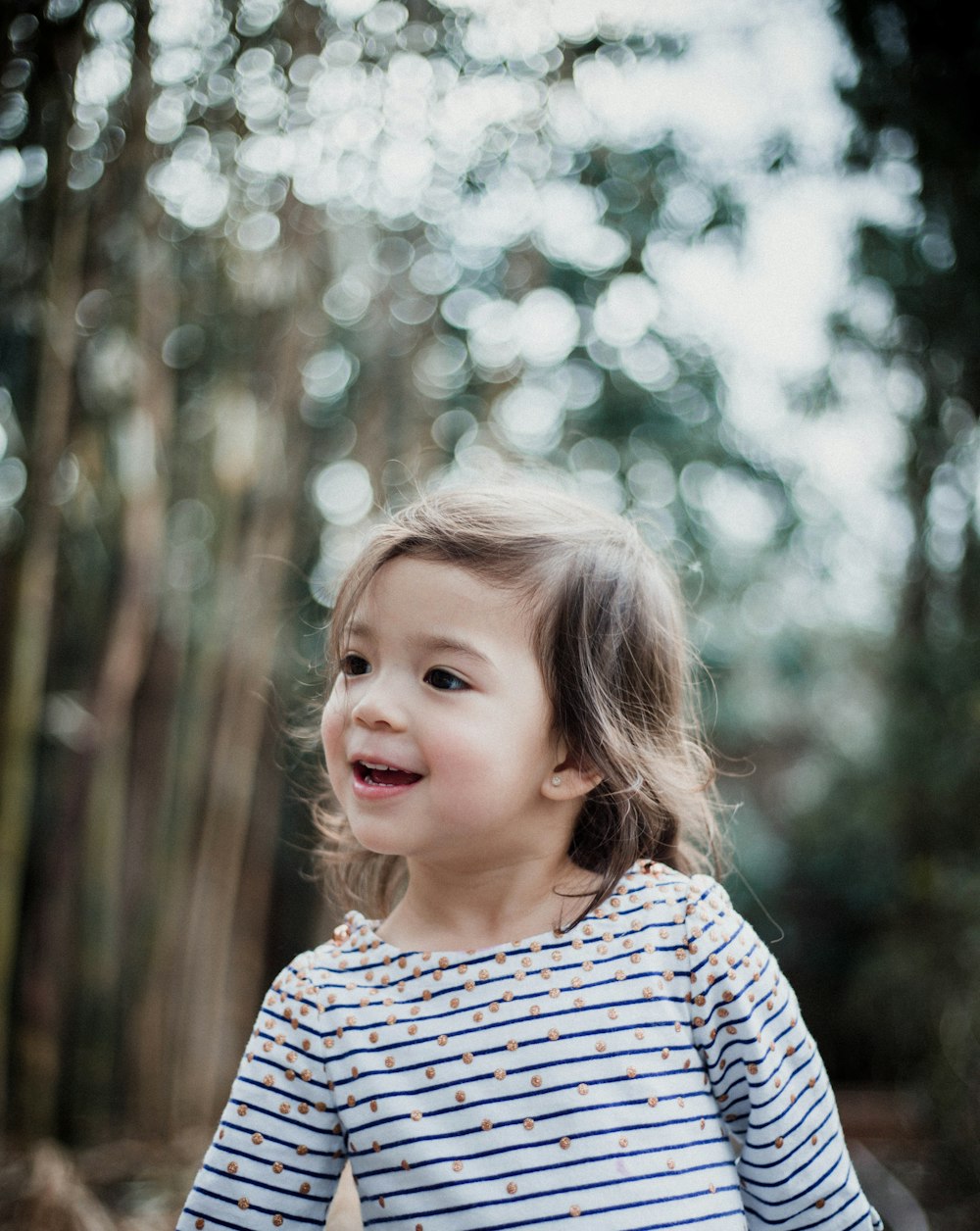 girl wearing white striped shirt near on tree forest
