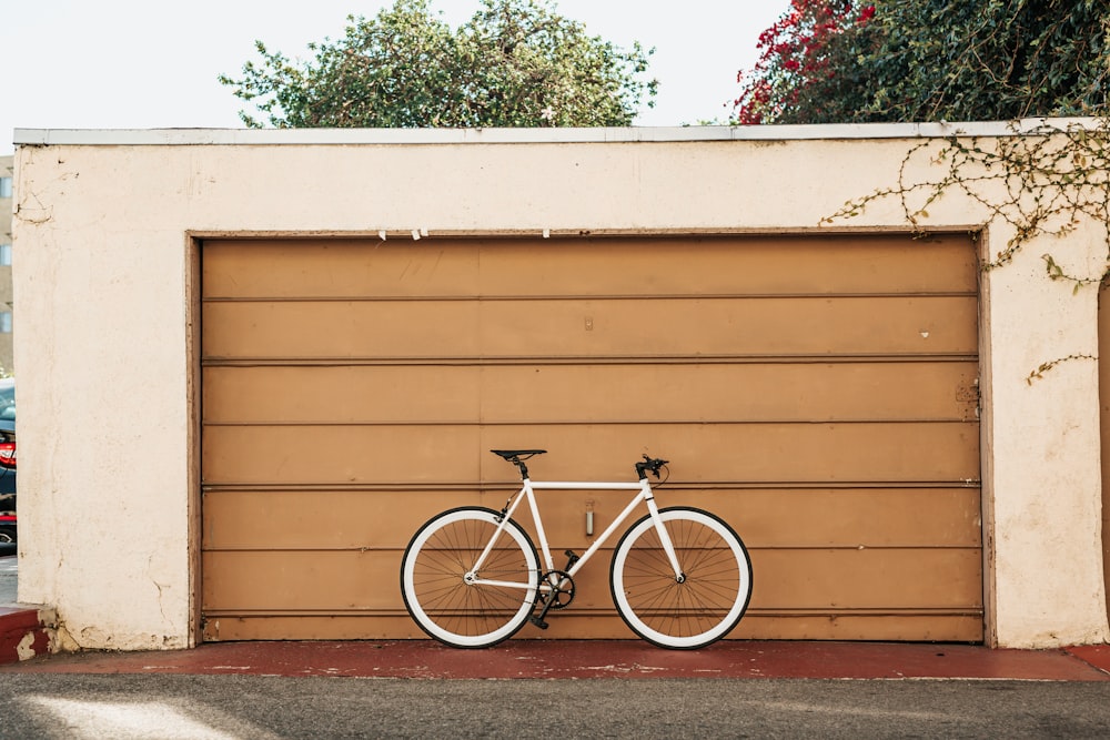 white bike leaning on brown roller shutter