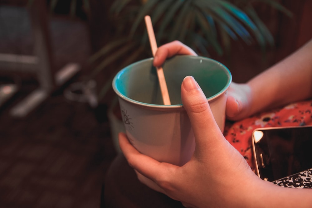 person holding bowl with chopstick
