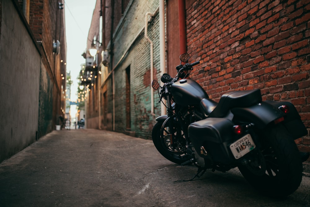 black cruiser motorcycle parked at the middle of the alley