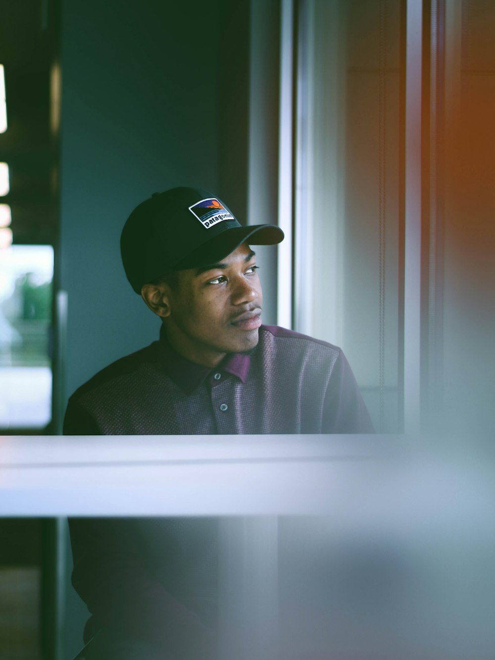 man wearing gray and purple polo shirt inside room