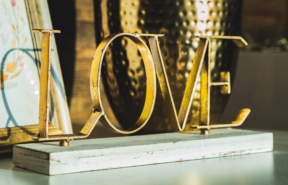 Decoración de mesa de letras independientes de amor dorado sobre superficie blanca