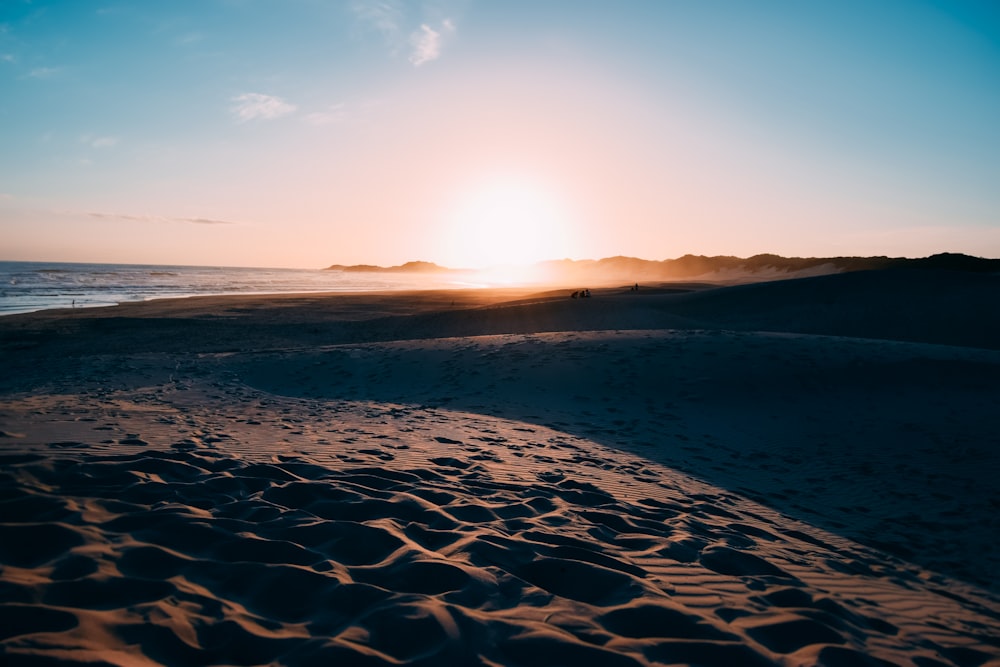 Plage de sable brun au coucher du soleil