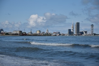 Coastal city skyline with rising sea levels visible at waterfront.