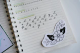 Hand-drawn notebook page with stickers representing workshops and digital resources.