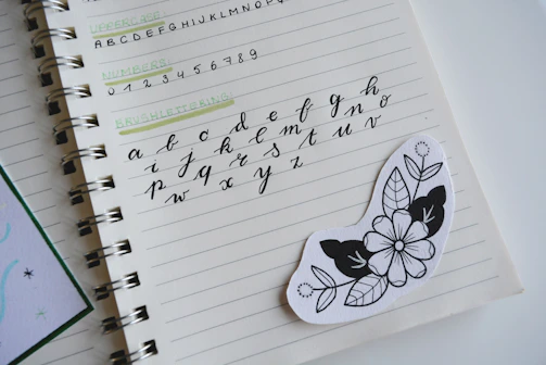 Hand-drawn notebook page with stickers representing workshops and digital resources.