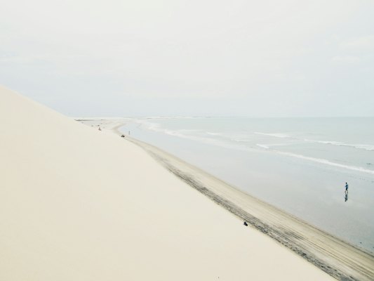 A walker on the long empty beach — Jericoacoara, Brazil
