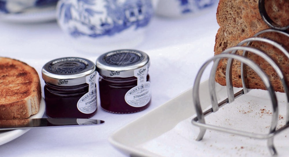 two glass jars near toasted bread