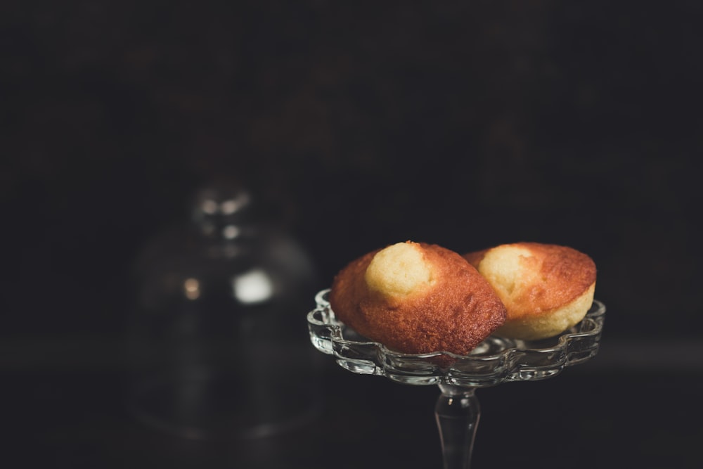 two baked breads placed on clear glass cupcake stand in focus photography