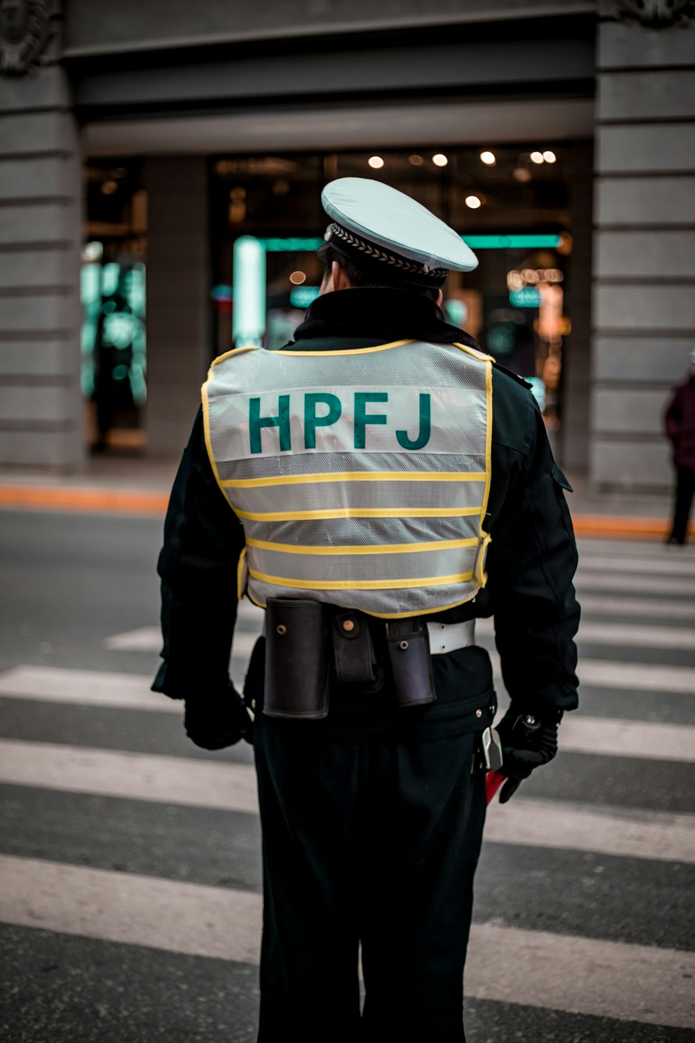 man wearing black and gray HPFJ suit standing on crosswalk closeup pho o