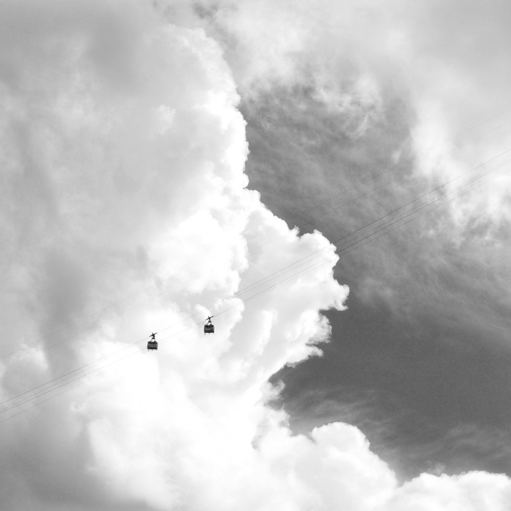 Deux téléphériques noirs sous un ciel gris