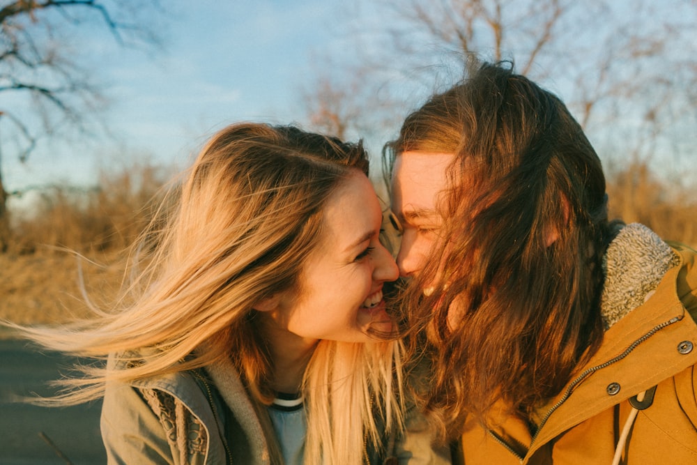 homem e mulher de frente um para o outro enquanto sorriem