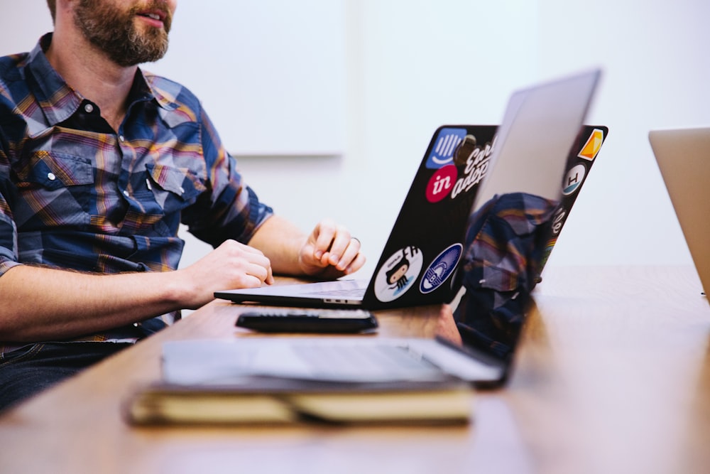 Mann sitzt vor Laptop