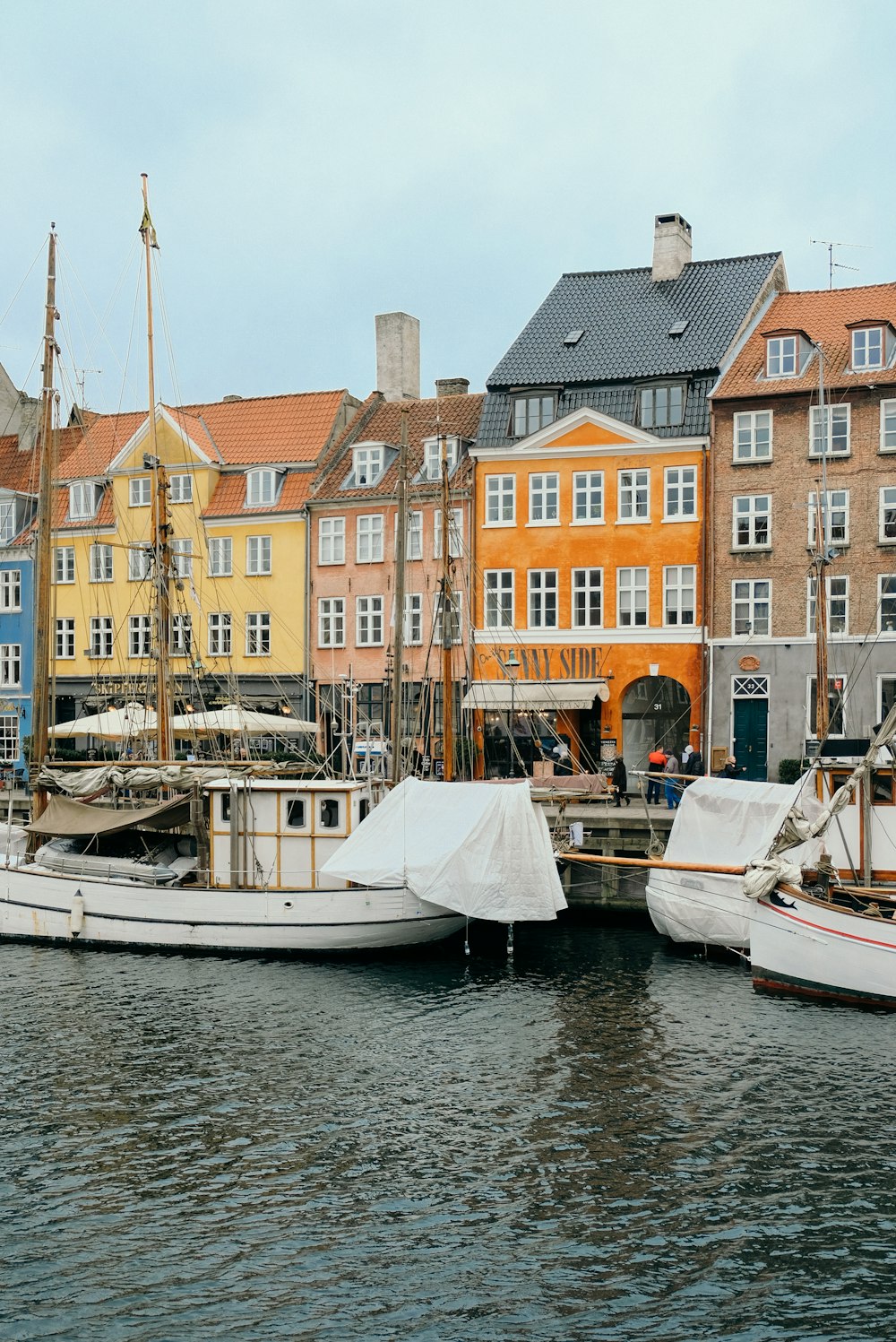 white wooden boats docks near assorted-color concrete houses during daytime