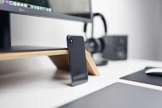 A sleek black and gold-themed workspace with electronic gadgets and a smartphone displaying a user manual app.