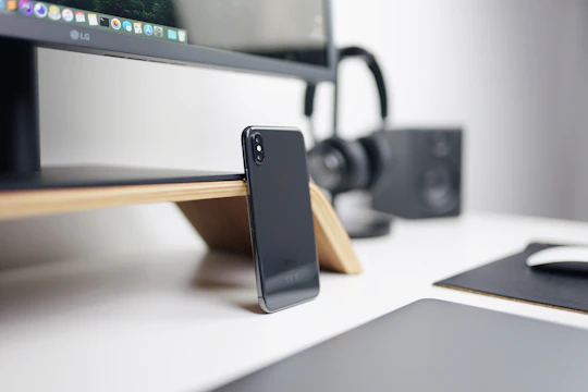 A modern communication device with a clear display and ergonomic design resting on a tech workspace.