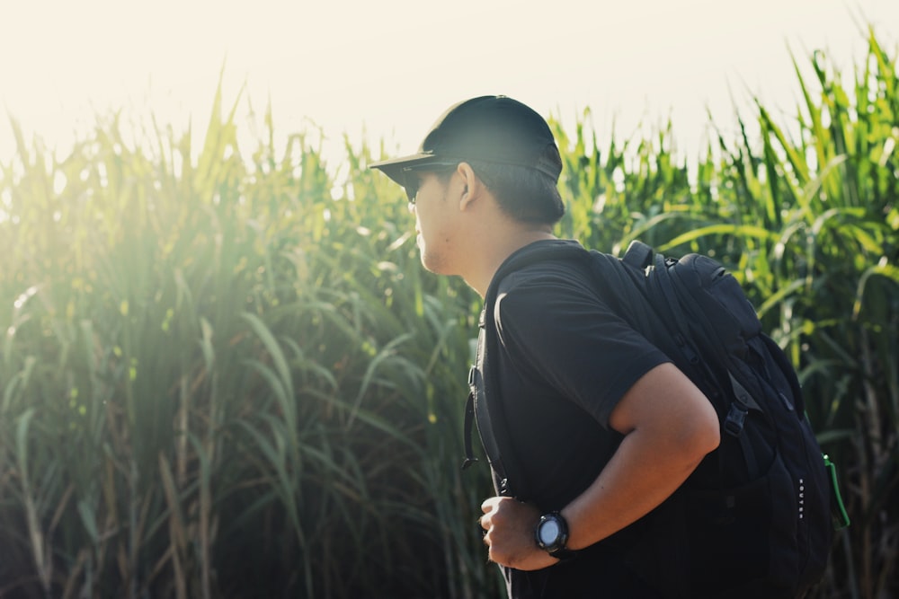 man standing beside grass field