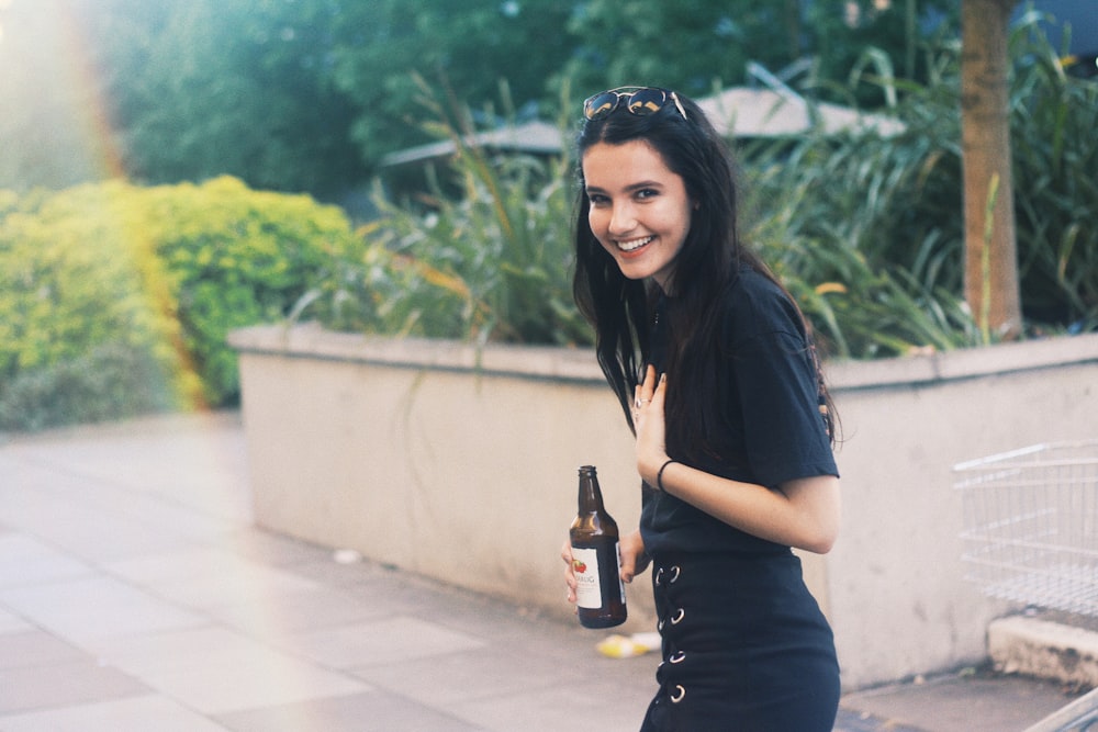 woman holding black bottle in rule of thirds photography