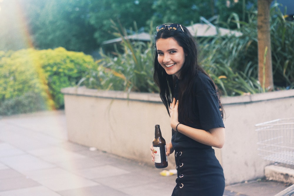 donna che tiene la bottiglia nera nella regola della fotografia dei terzi