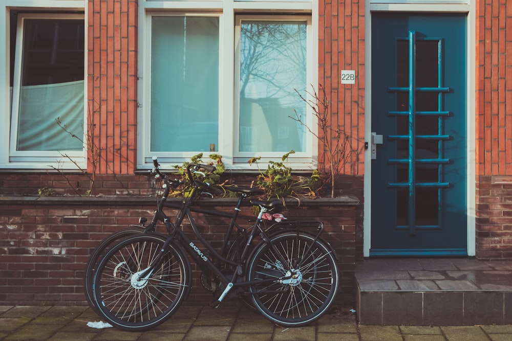 black road bicycles beside brown concrete wall during daytime