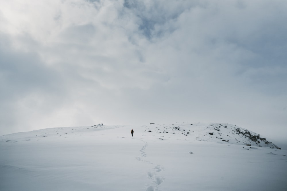 persona che cammina sulla montagna durante la stagione invernale