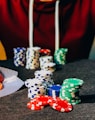 person sitting near poker chips