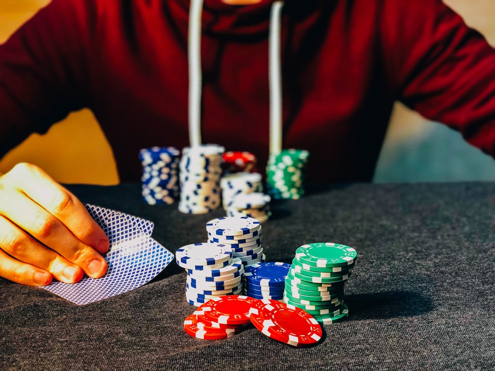 person sitting near poker chips