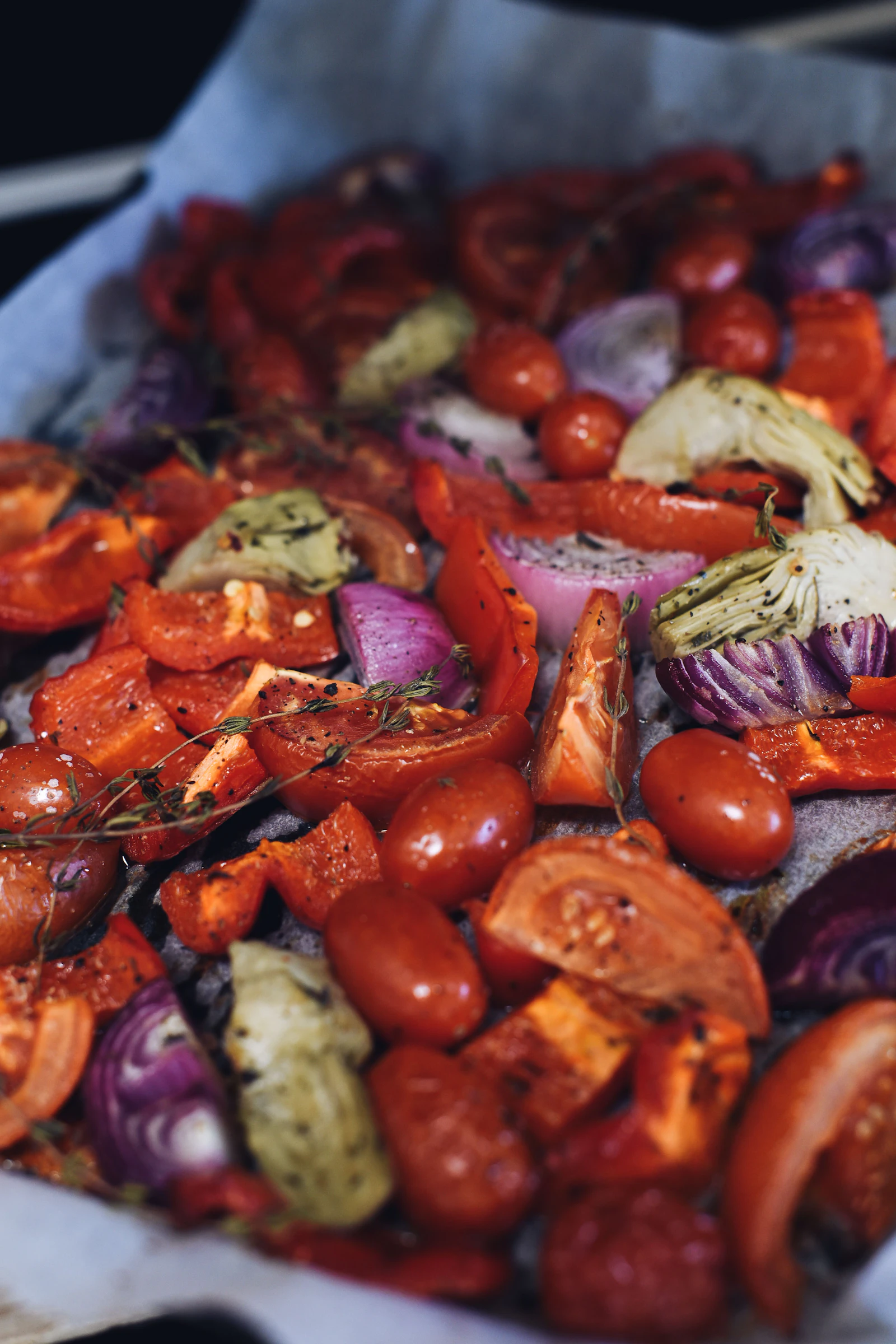 Légumes rôtis marinés, poivrons, tomates et oignons rouges au thym sur une plaque