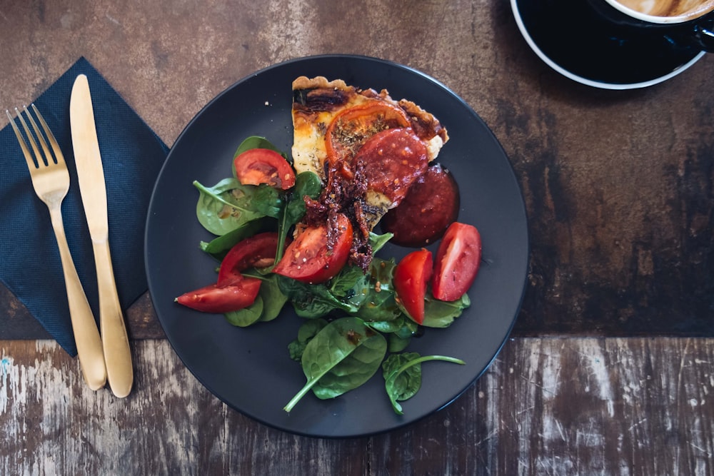 sliced tomato dish on black plate