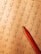 A math worksheet filled with various multiplication and division problems is accompanied by a red pencil resting on the paper. The writing appears to be handwritten, with some numbers scribbled or crossed out as part of corrections or workings.