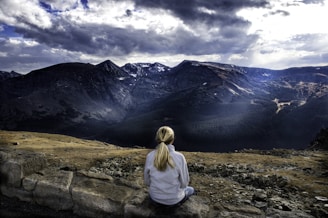 woman sitting on gray stone