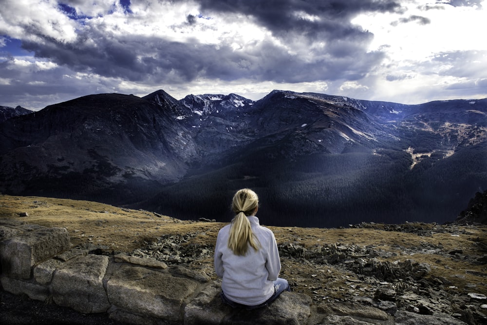 woman sitting on gray stone