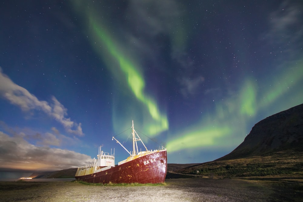 focusphotography of red and white ship on the shoreline