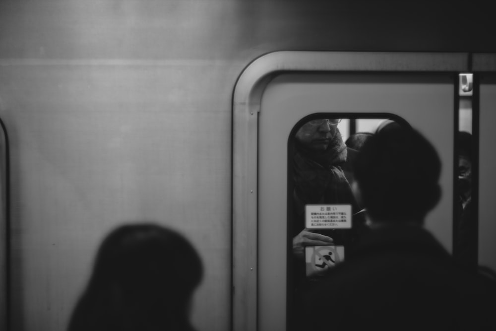 person standing on train door