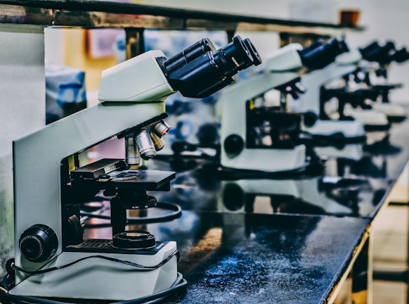 white microscope on top of black table