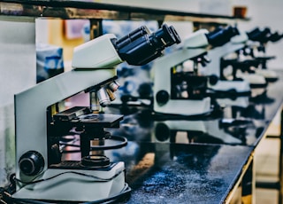 white microscope on top of black table